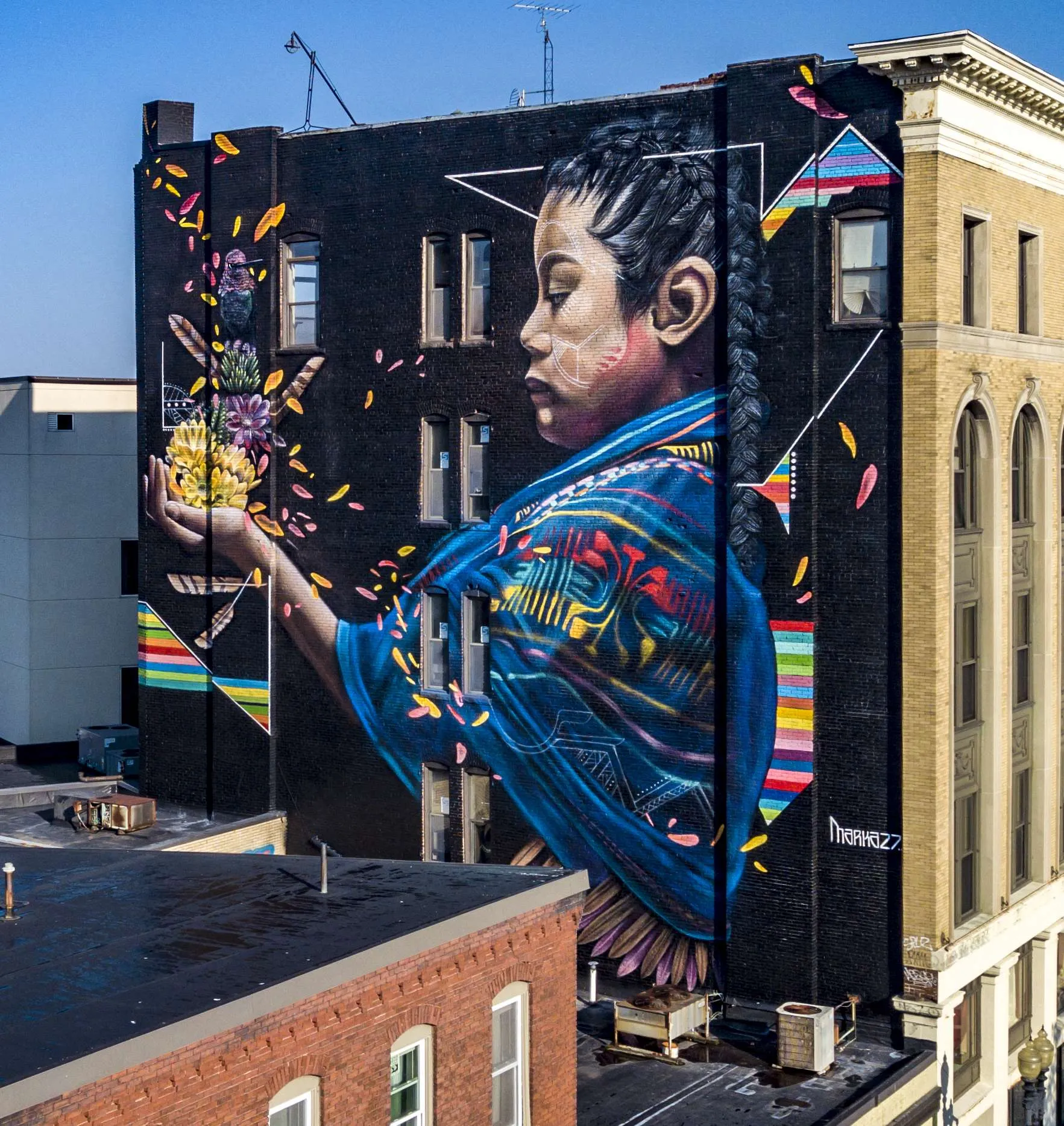 a large mural of a boy holding a vase of flowers.