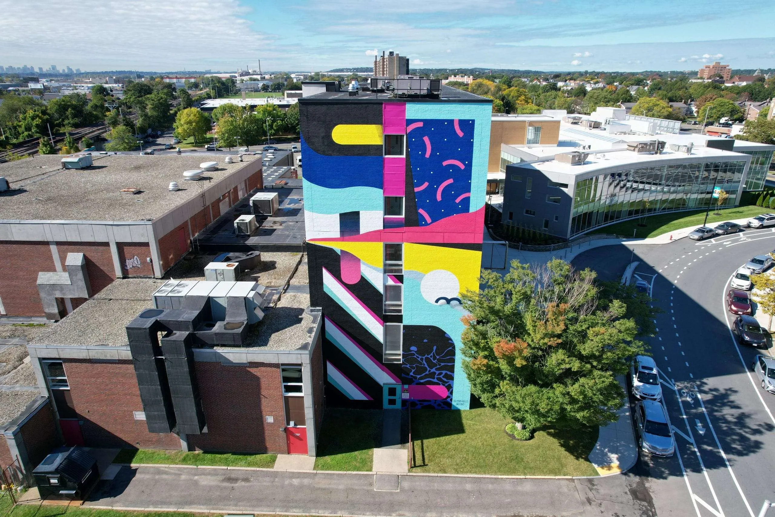 an aerial view of a multi - colored building in a city.