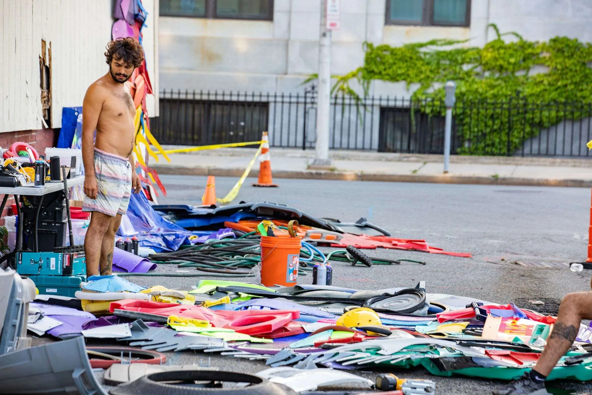 a man standing next to a pile of clothes.
