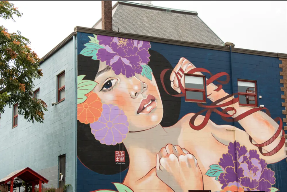 a large mural of a woman with flowers on her head.