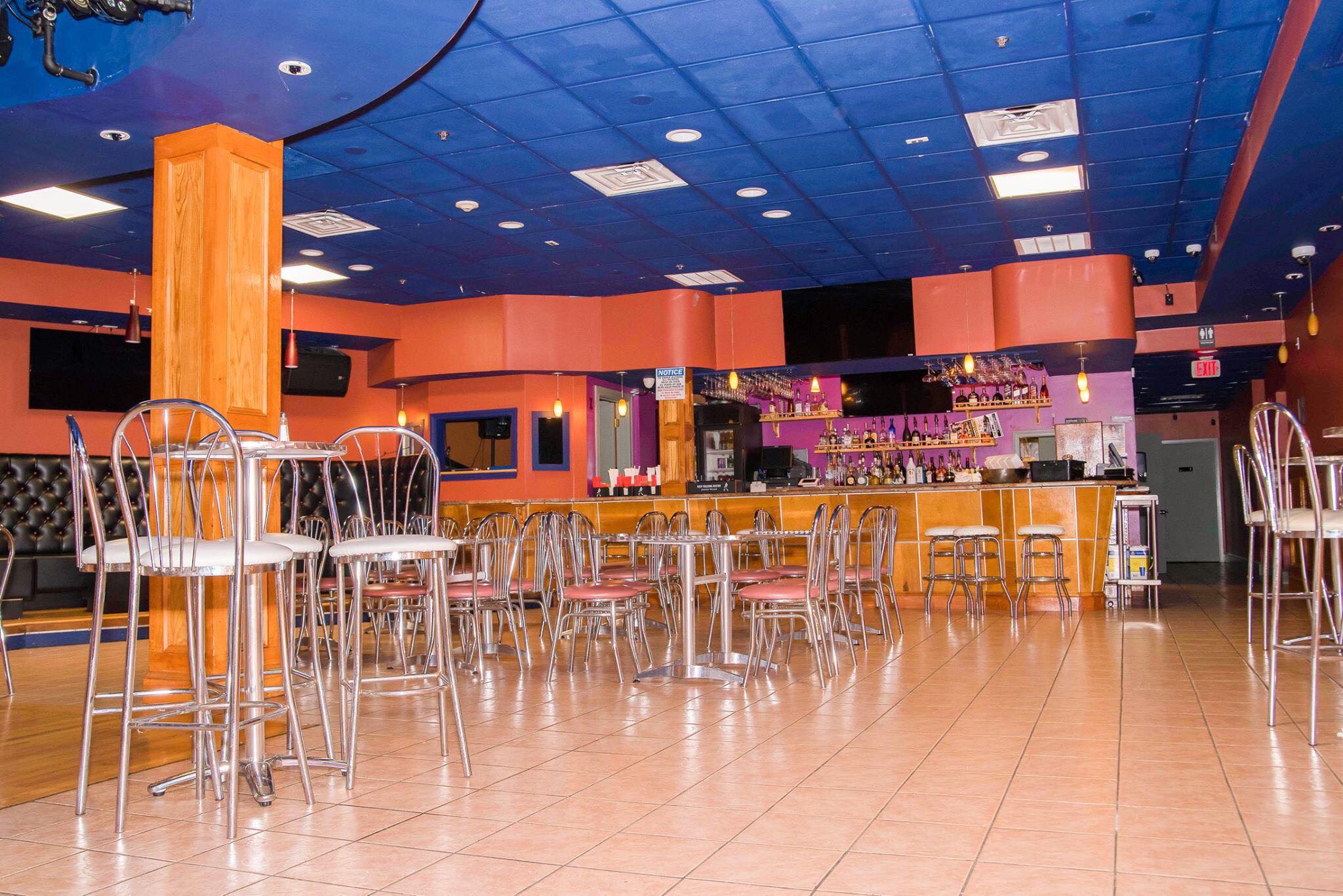 a restaurant with a tiled floor and orange walls.