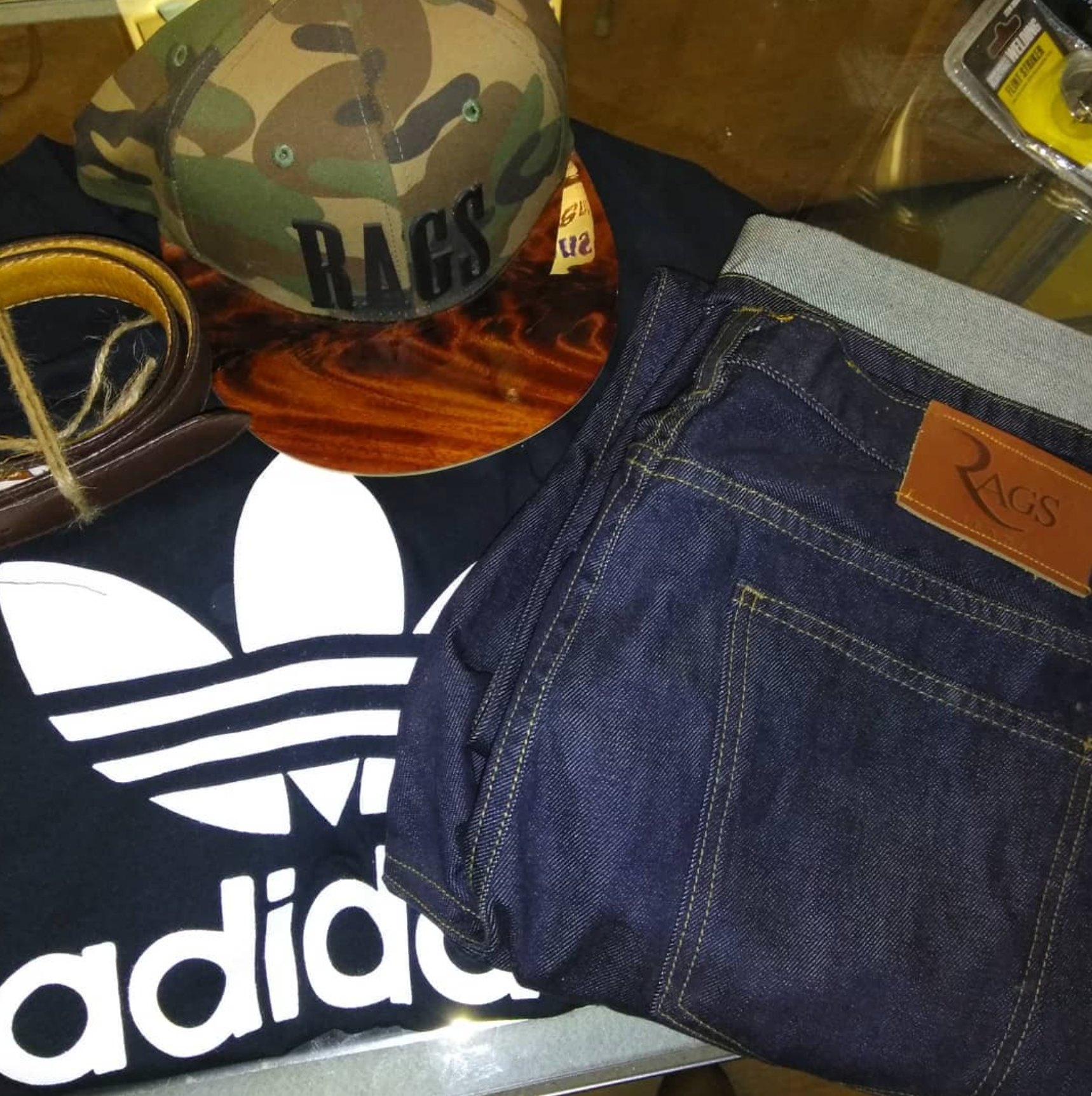 a pair of jeans, a hat, and other items are on a table.