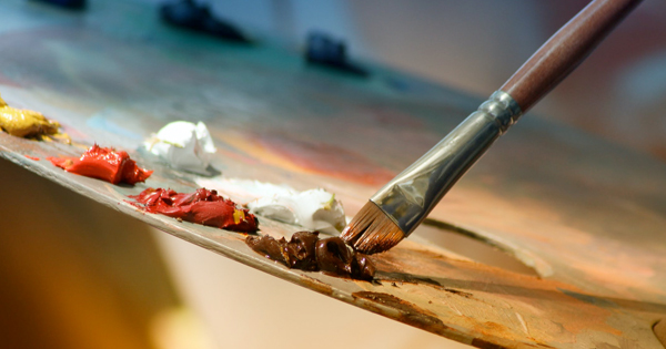 a paintbrush is being used to paint a piece of art.
