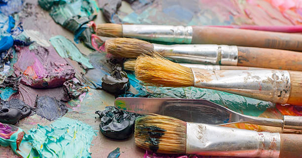 a group of paint brushes sitting on top of a table.