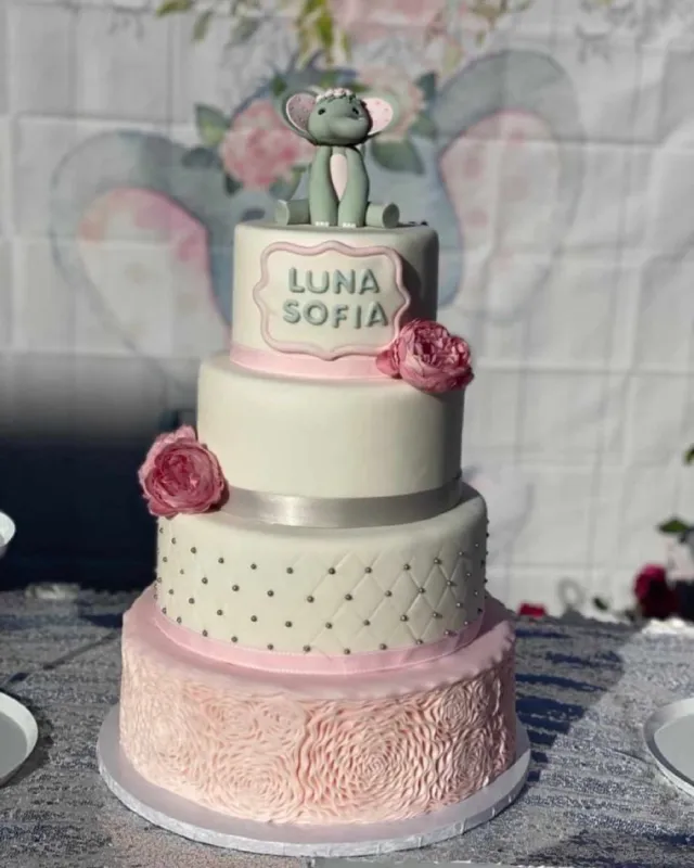 a three tiered cake with a elephant on top of it.
