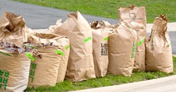 a bunch of bags sitting on the side of a road.