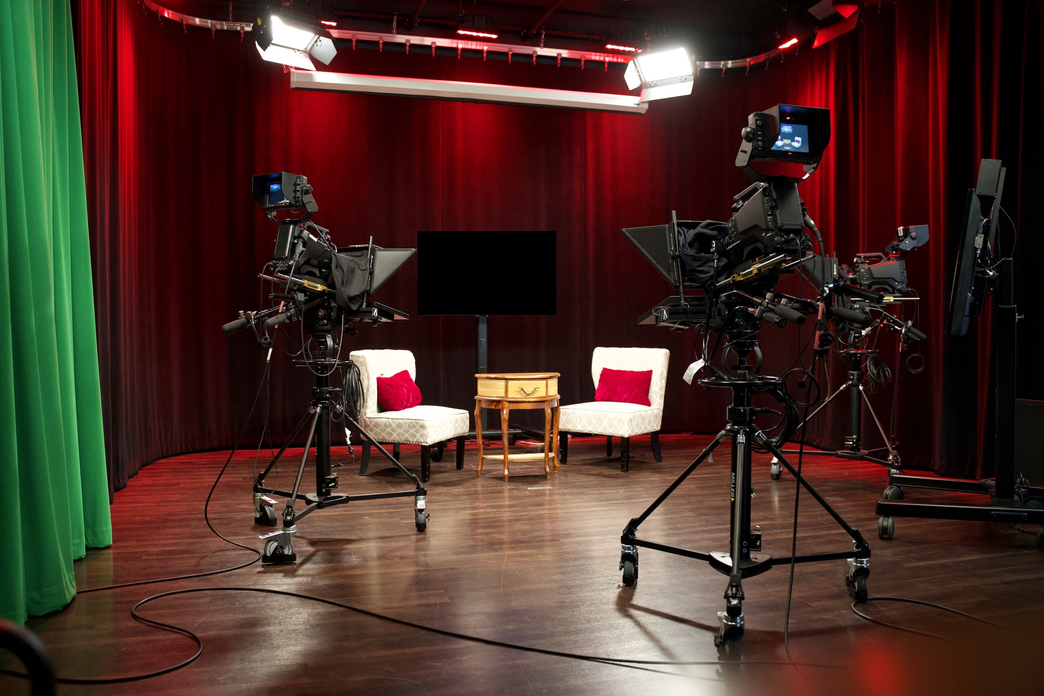 a camera set up in front of a red curtain.