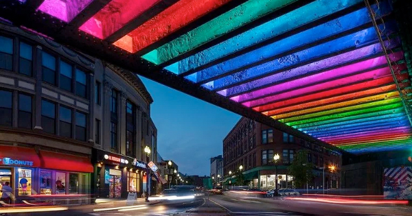 a rainbow colored canopy over a city street.