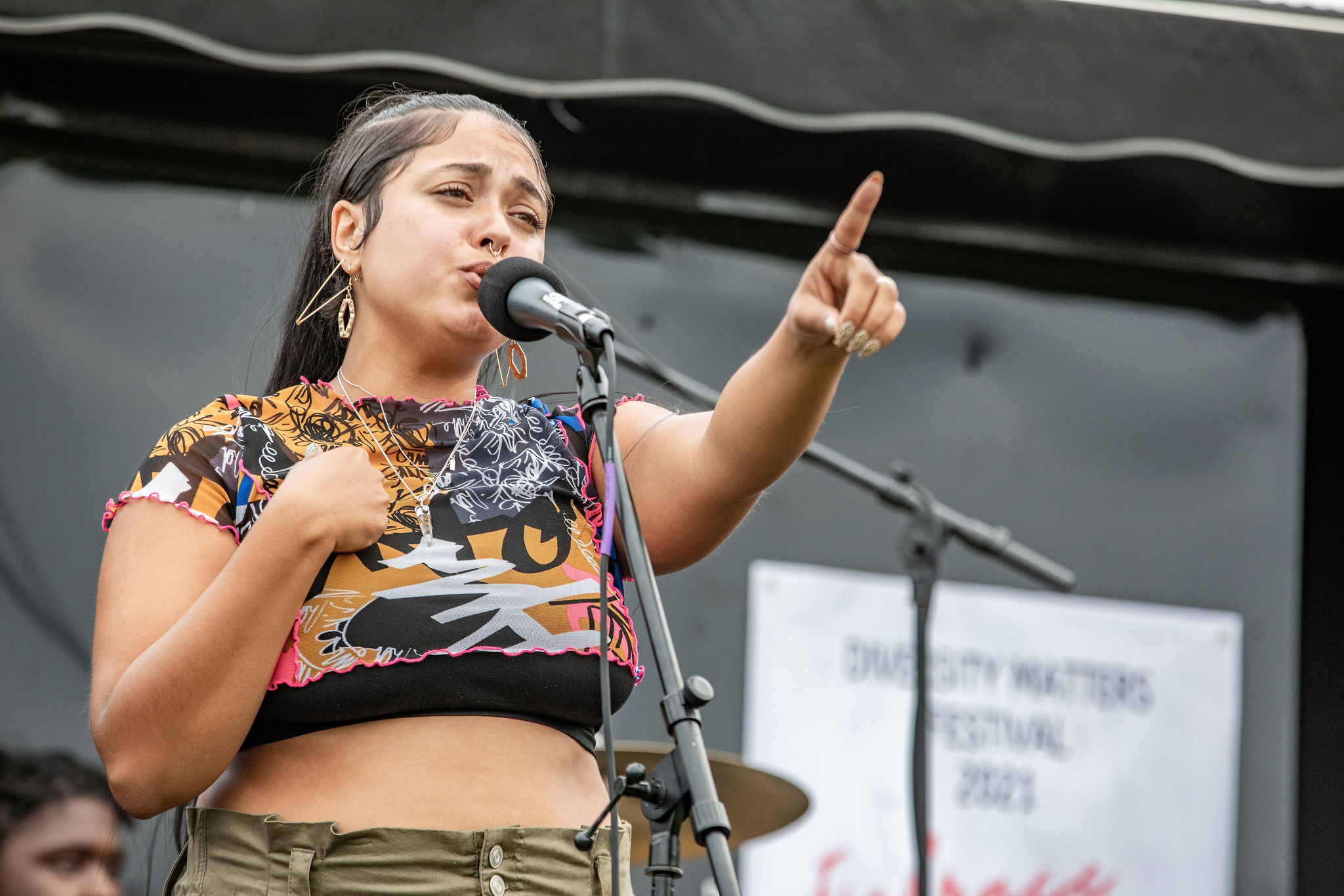 a woman in a crop top singing into a microphone.