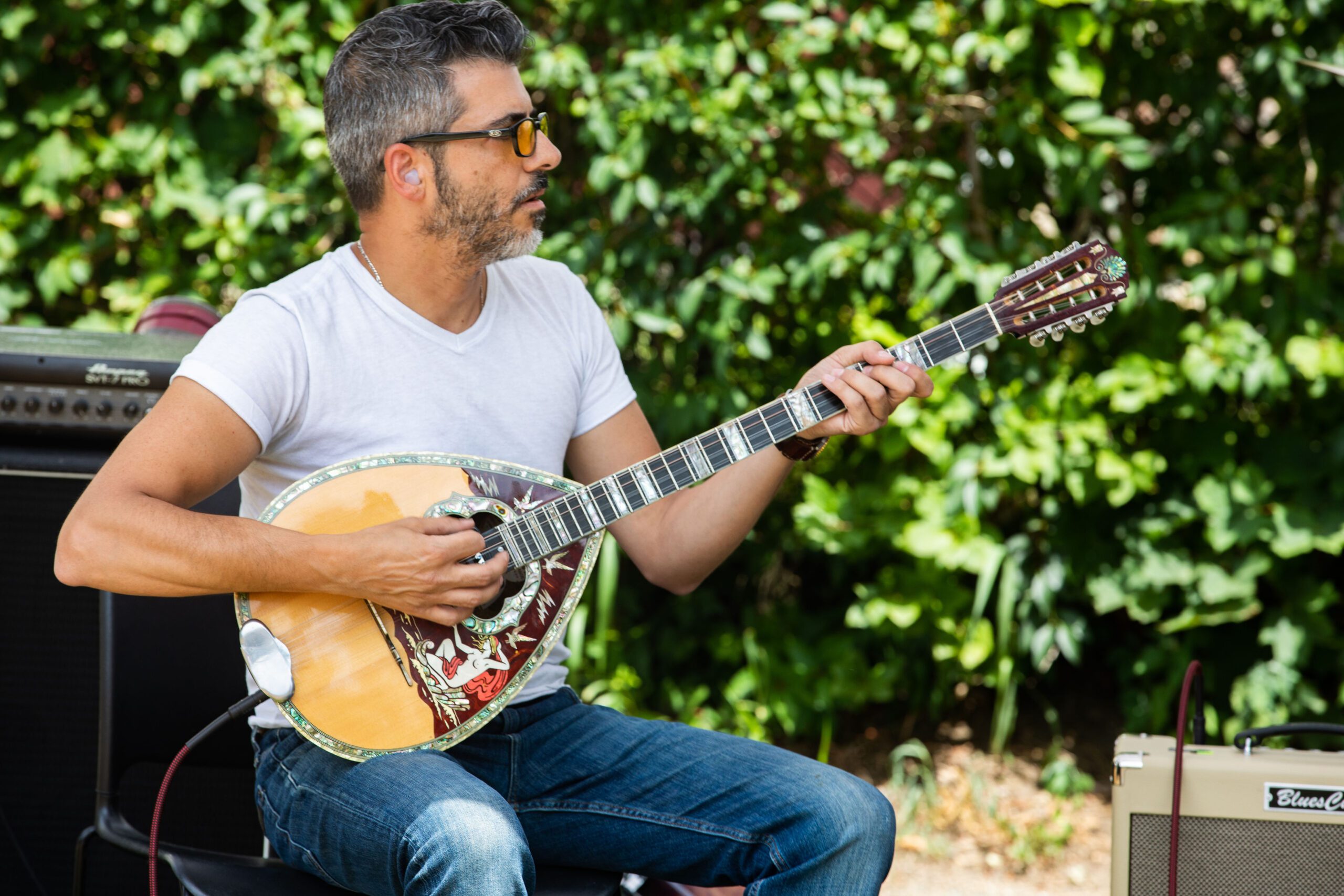 a man playing an acoustic guitar in a park.