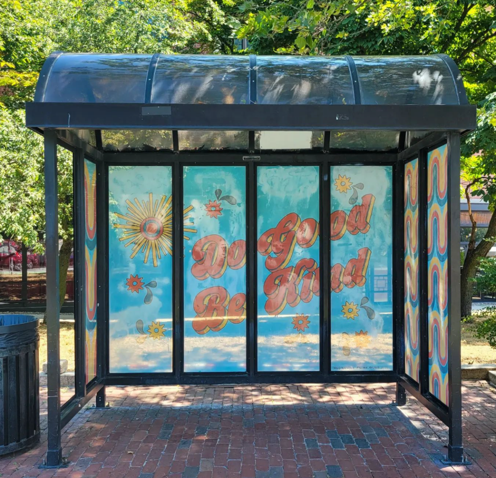 a bus stop with a mural on it.