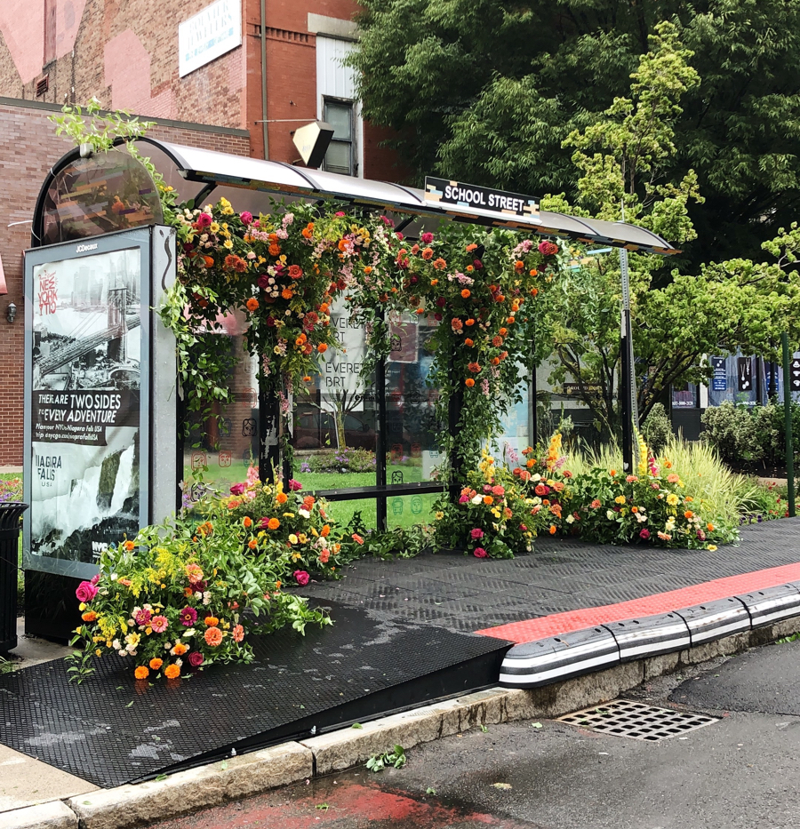 a bus stop with flowers on it.
