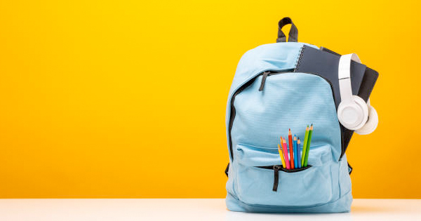 A blue backpack with headphones and pencils on a yellow background.