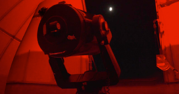 A telescope in a dark room with a red light.