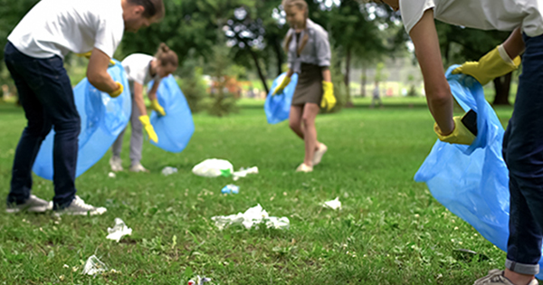 A group of people picking up trash in a park.