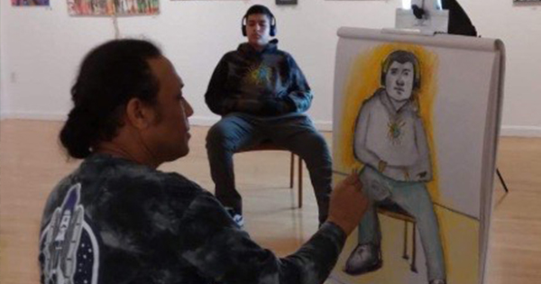 An artist is capturing the essence of a person wearing headphones in an art studio. The sketch shows the seated individual, while vibrant paintings adorn the walls in the background. The scene blends creativity and focus, making it perfect for any art-related content or blog post.