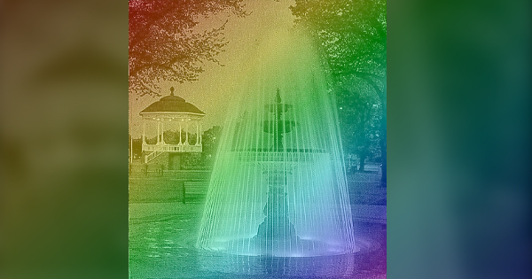 Our vibrant park fountain sparkles with rainbow lights, inviting our community to gather by trees, benches, and a dreamy white gazebo.