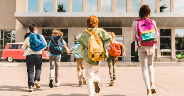 Six spirited kids with backpacks stride toward their school in Essex County, radiating excitement and a vibrant sense of community.