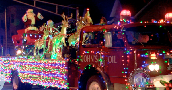 A festive red truck lit with dazzling lights and Santa’s display spreads joy at our Essex County parade, powered by JOHN'S OIL.