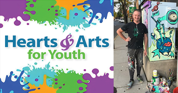 A creative local artist in vibrant, paint-splattered clothes beams beside a lively utility box, celebrating Essex County youth arts. "Hearts & Arts for Youth" shines amidst colorful paint splatters, sparking community spirit and connection.