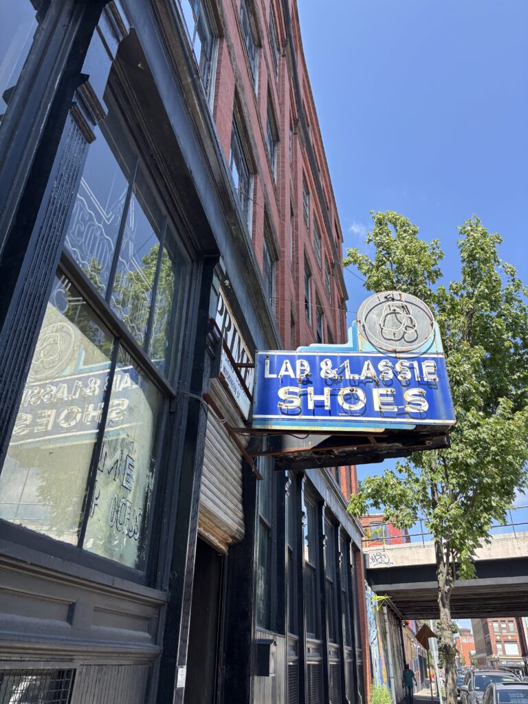Historic Lad & Lassie Shoes neon sign on the exterior building of Lynn Vintage Warehouse at 545 Washington St in Lynn MA marking the entrance to the vintage warehouse