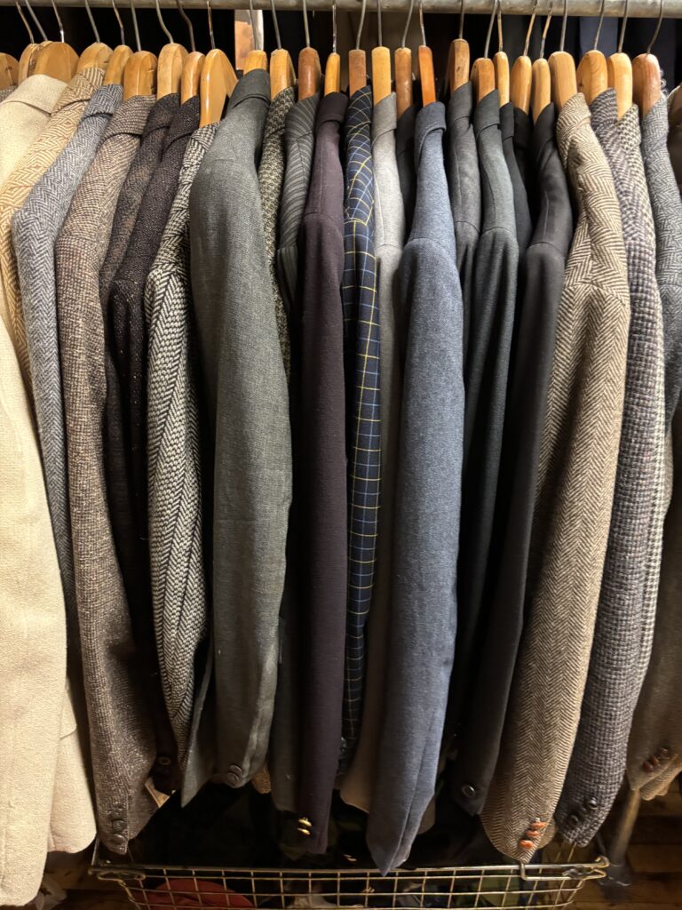 Rack of vintage tweed blazers and men's suit jackets for sale at Lynn Vintage Warehouse on the North Shore