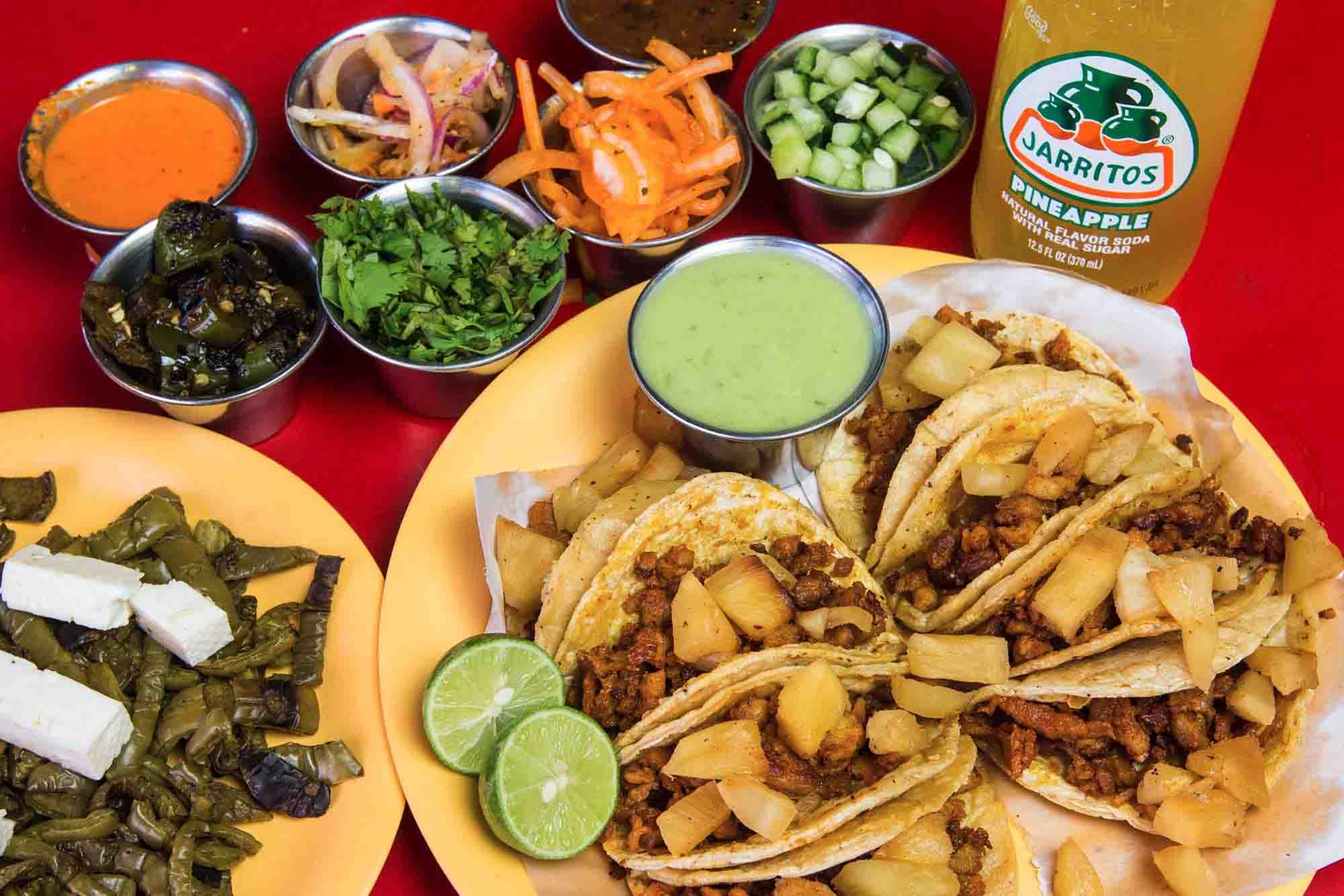 Authentic tacos al pastor topped with diced pineapple served with fresh salsas and Jarritos soda at Tacos Lupita in Downtown Lynn MA